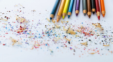 Color pencils and pencil shavings on white background