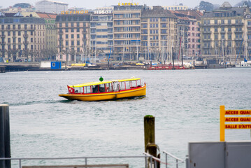 Border of Lake Geneva at City of Geneva with Cityscape in the background and public transport ship...