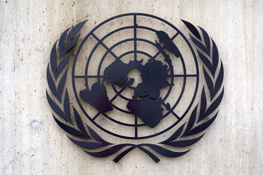 United Nations logo at UN building wall at Geneva on a cloudy spring day. Photo taken March 18th, 2022, Geneva, Switzerland.