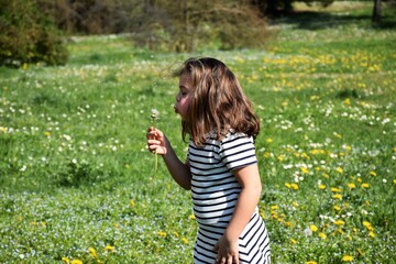 Bambina gioca felice nel prato fiorito