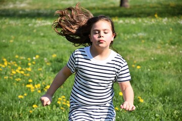 Bambina felice di correre nel prato fiorito