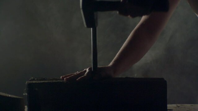 Hammer hitting a big nail in a dramatic misty ambience