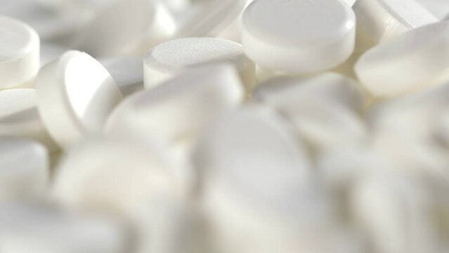 The medicine concept.white medical pills rotating closeup. Pills and drugs. Pharmaceutical Industry. drugs on the production line. moving background. close-up. view from above.super slow motion
