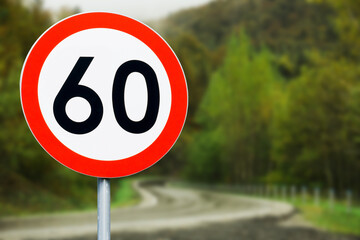 Speed limit sign with curvy road behind. Maximum sixty kilometers per hour. Safety on road background. White round sign red border line. Traffic ticket background. Speeding fine. Slow down on turn.