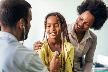 Healthcare medical exam people child concept. Close up of happy girl and doctor with stethoscope