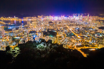 Fototapeta premium Men hiking at the Lion Rock Peak, Hong Kong night view, panorama from Kowloon district to Hong Kong Island, Asis