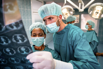 Healthcare and medical concept. Group of doctors looking at x-ray before operation