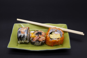 Japanese food, seaweed roe roll sushi in white plate, with sauce, black background,Include Clipping Path.