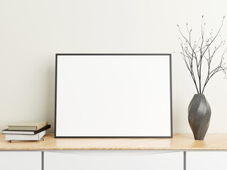 Minimalist horizontal black poster or photo frame mockup on wood table with books and vase in a room