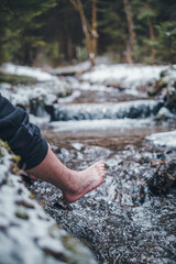 hanging bare feet over the river in the woods