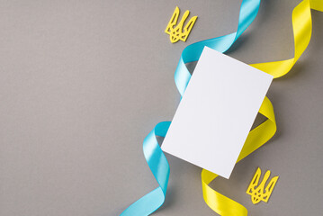 Stop the war in Ukraine concept. Top view photo of paper card golden tridents and national flag...
