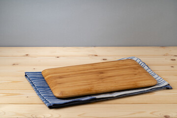 Cutting board with cotton napkin on wooden table