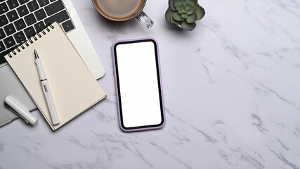 Mock up mobile phone, laptop, coffee cup and notebook on marble background. Flat lay.