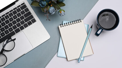 Flat lay notebook, computer laptop, glasses and coffee cup on white table.