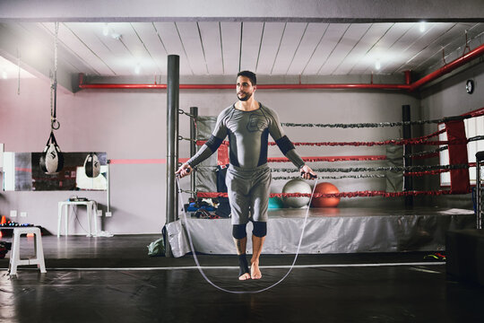 This is what I do before every session. Shot of a focused young male boxer using a skipping rope for training exercises inside of a gym during the day.