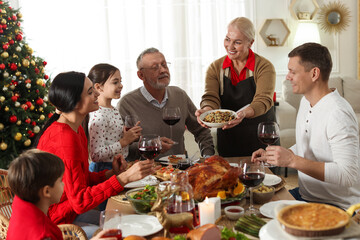 Woman with bowl of traditional Christmas kutia and her family during festive dinner at home. Slavic dish