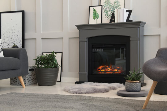 Stylish living room interior with electric fireplace and comfortable furniture