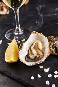 Fresh opened oyster with lemon on slate plate