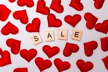 Sale inscription, a lot of red hearts on a white background.
