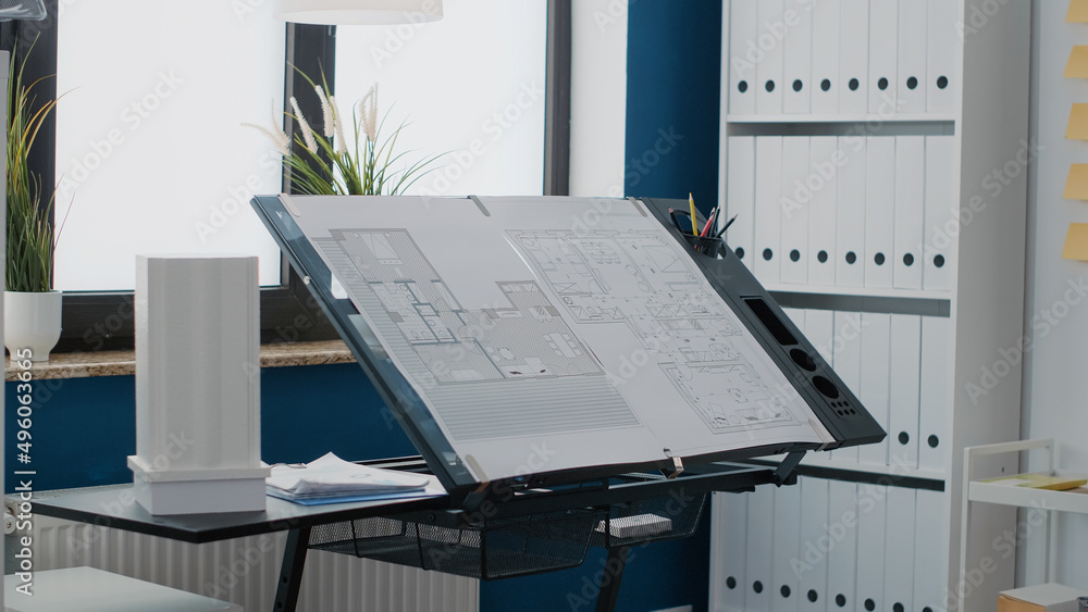 Poster close up of blueprints plans to design building layout on table in workplace. empty office with indu