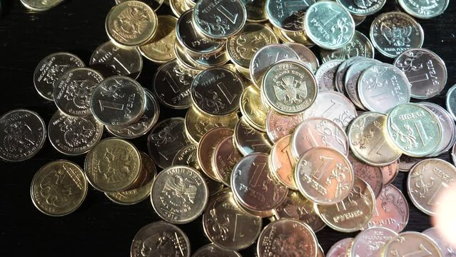 Russian coins fall from the hands on the table. Russian ruble