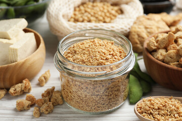 Dehydrated soy meat and other organic products on white wooden table, closeup