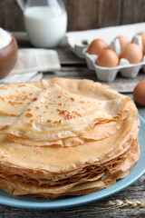 Stack of delicious crepes on wooden table, closeup