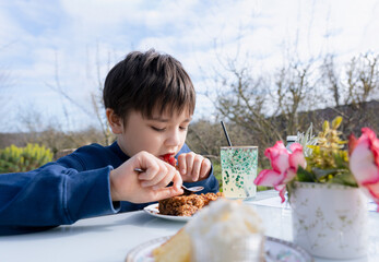 Hungry young boy eating flapjack for dessert,Kid having organic vegan homemade oatmeal bars with...