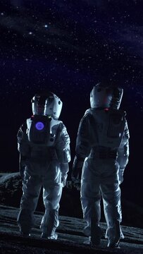 Two Astronauts in Space Suits Standing on the Alien Planet Look at Dark Sky. Space Travel, Habitable World and Colonization Concept. Video Footage with Vertical Screen Orientation