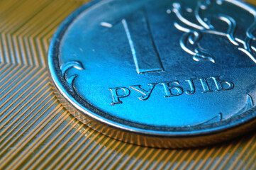 A coin with a face value of 1 ruble lies on a microcircuit. close-up. Translation of the inscription on the coin: 
