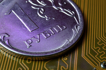 A coin with a face value of 1 ruble lies on a microcircuit. close-up. Translation of the inscription on the coin: "1 ruble" The concept of the digital economy in the Russian Federation