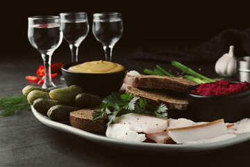 Tasty salt pork with rye bread and sauces served on grey table