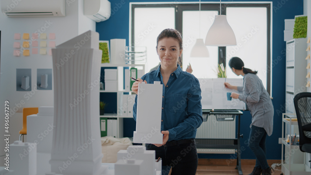 Poster portrait of employee working with building model and maquette to design blueprint plan for urban con