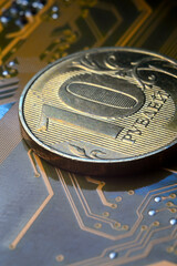 A coin with a face value of 10 rubles lies on a microcircuit. close-up. Translation of the inscription on the coin: 