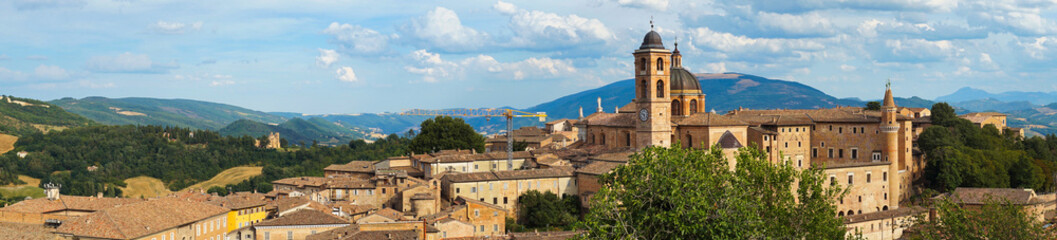Fototapeta na wymiar Panoramic view of the city of Urbino, Italy. Ancient italian renaissance city, Unesco world heritage site. Houses, palaces, cathedrals and towers of the Doge's Palace under a cloudy sky.