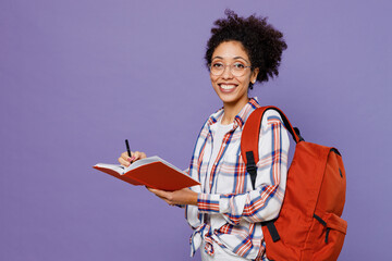 Young girl woman of African American ethnicity teen student in shirt backpack write down lecture in...