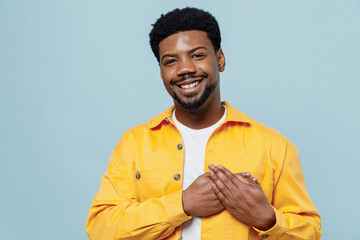 Young kind-hearted smiling happy thankful man of African American ethnicity wear yellow shirt put...