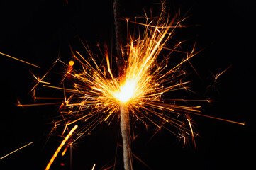 Close view of sparkler on black background. soft selective focus. abstract bokeh background, copy space. Christmas or New Year composition. Christmas card.