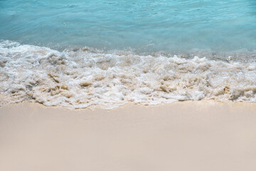 Fototapeta na wymiar Soft blue oceans weave with foam and clear white sand. Tropical beach by the ocean 