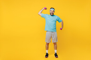 Fototapeta na wymiar Full size young fitness trainer instructor sporty man sportsman in headband blue t-shirt spend weekend in home gym hold dumbbells isolated on plain yellow background Workout sport motivation concept.