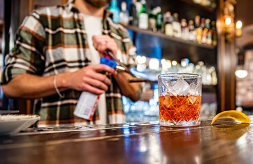 man hand bartender making glass negroni cocktail in bar