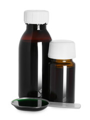 Bottles of cough syrup and dosing spoon on white background