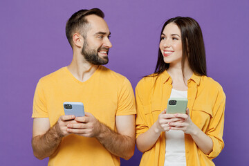 Young smiling happy fun couple two friends family man woman together in yellow casual clothes hold...