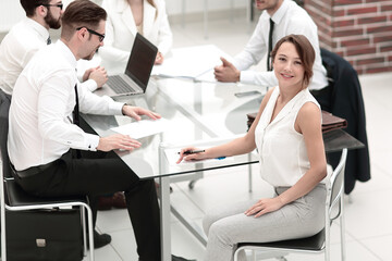 Obraz premium smiling employee and business team sitting at the Desk