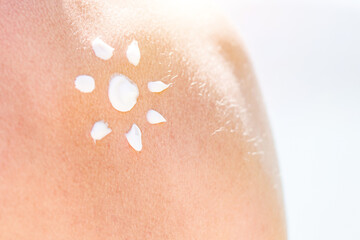 Fototapeta premium Skin and Body Care. Tanned Shoulder and Applying Sun Cream In Form Of The Sun. Sun Protection. Sun Cream.