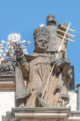 Ancient decorative top facade statues of priests, bishops at Saint Salvator church near Charles Bridge in Prague, Czech Republic, details, closeup