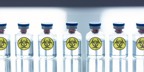 Prohibited development of warfare in a lab. A row of ampoules with a bio-hazard sign, close-up,...