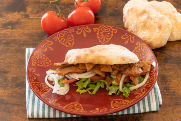 top view of a kebab in a plate on a wooden table