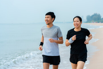 This young Asian couple, jogging in the cold wind together in the morning, the weather is nice and...