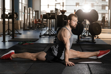 Fototapeta na wymiar man sit on the twine in the gym after a workout